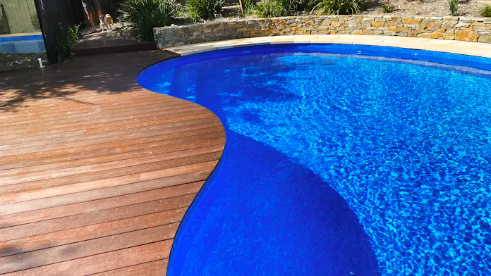 Eltham, Melbourne landscaping with timber pool decking and rock wall