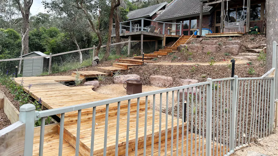 Eltham, Melbourne home with renovated backyard including timber boardwalks down through a newly installed low maintenance garden by Land Sculpture