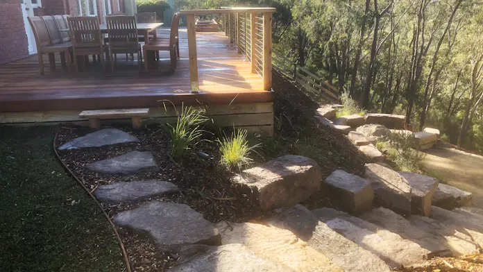 Very steep bushland block in Warrandyte, Melbourne after landscaping work by Land Sculpture including large mud rocks, planting, mulching, pathways and a large timber decking