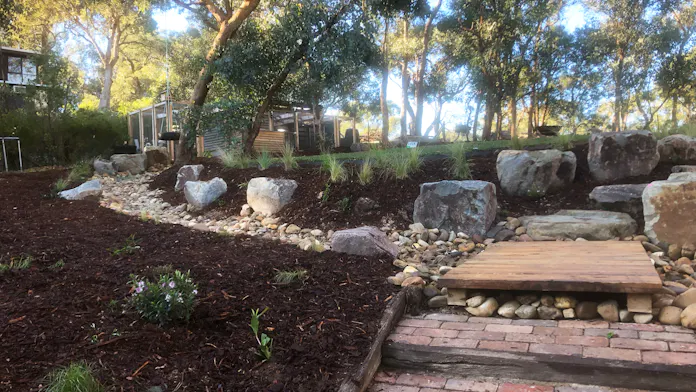 Rural Warrandyte, Melbourne storm water management landscaping by Land Sculpture with rocky creek bed to aid water runoff, timber landing and new planting